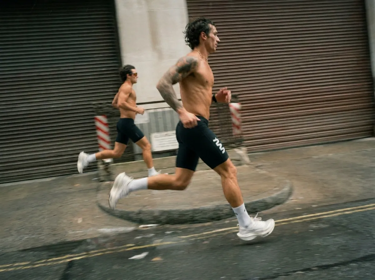 Two runners sprinting through a city street at speed